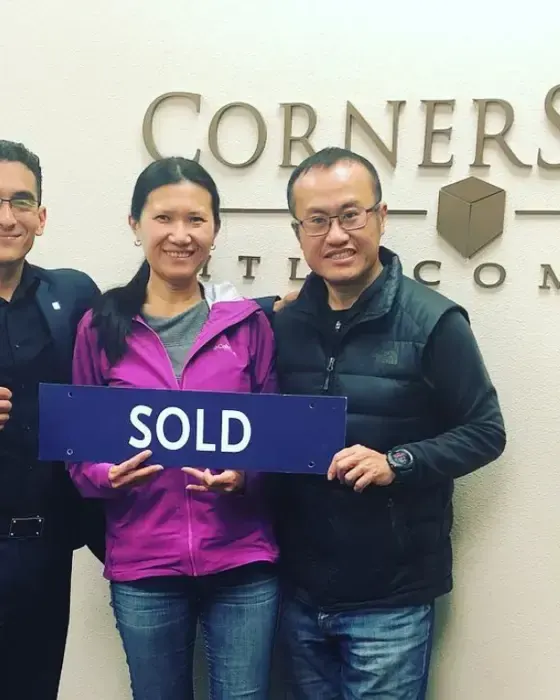 Nestor Icaza's clients holding a SOLD sign on closing day for their San Bruno or Peninsula home