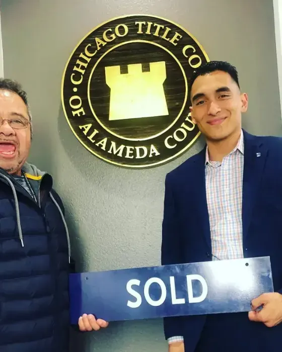 Nestor Icaza's clients holding a SOLD sign on closing day for their San Bruno or Peninsula home