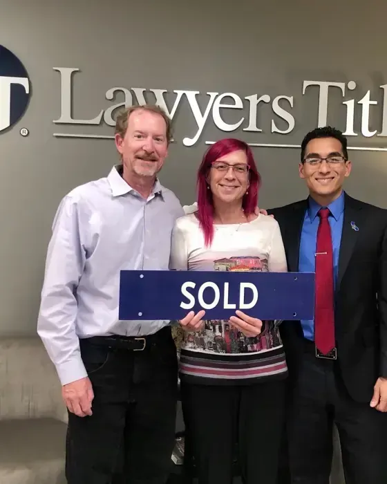 Nestor Icaza's clients holding a SOLD sign on closing day for their San Bruno or Peninsula home